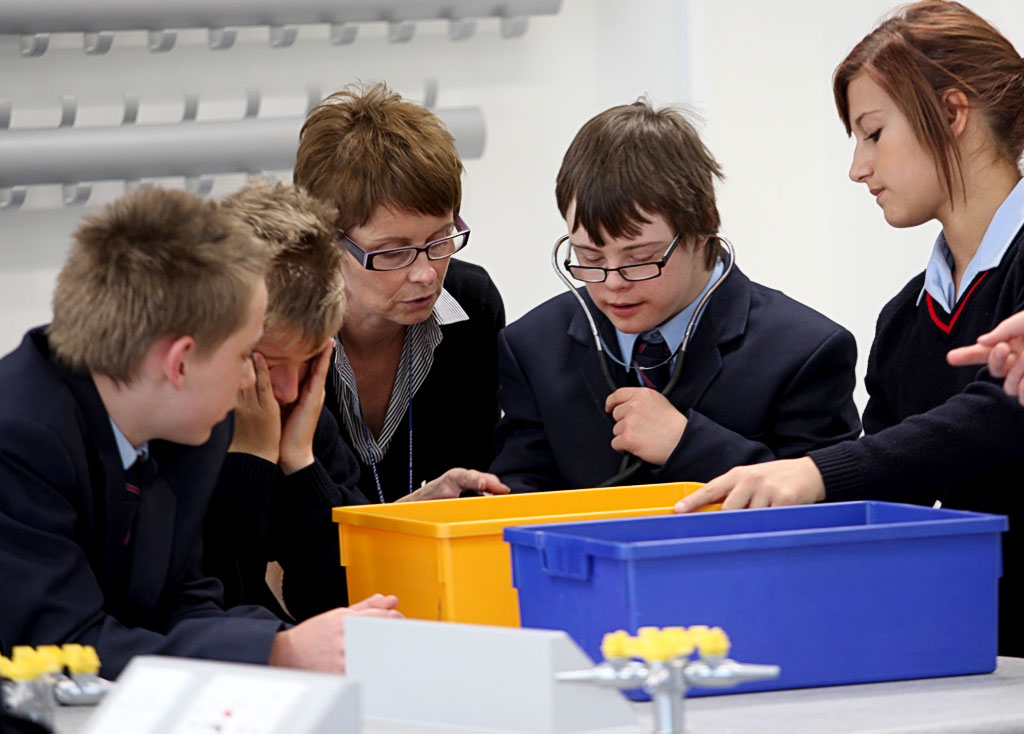 Down Syndrome - one to one teaching at school girl with tablet device.