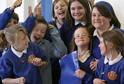 School children celebrating with a young girl with down syndrome